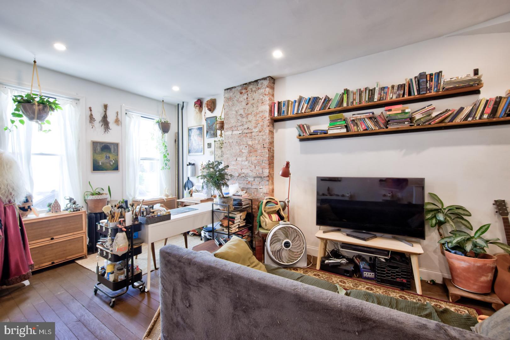 2044 Tasker Street Philadelphia, PA 19145 - Photo 2 of 15 a living room with furniture a flat screen tv and a fireplace