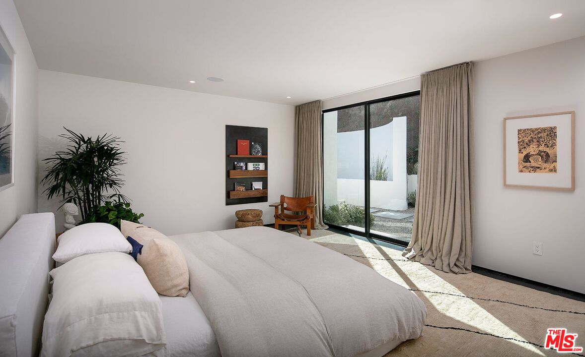 1731 Rising Glen Road Los Angeles, CA 90069 - Photo 17 of 27 a bedroom with a large bed and a large window