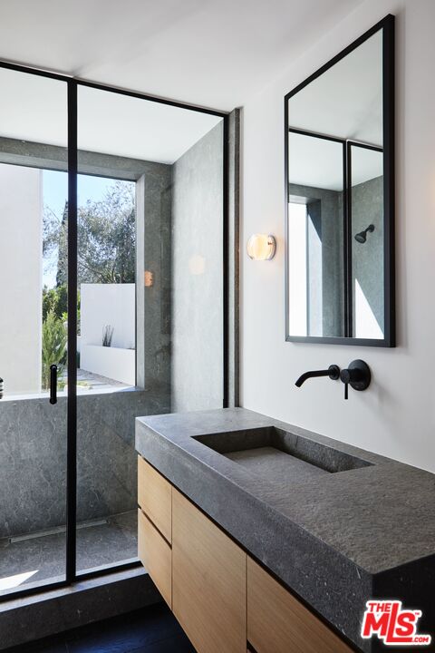 1731 Rising Glen Road Los Angeles, CA 90069 - Photo 18 of 27 a bathroom with a granite countertop sink and a mirror