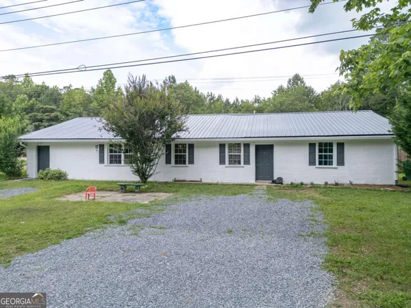 a front view of a house with a yard and trees
