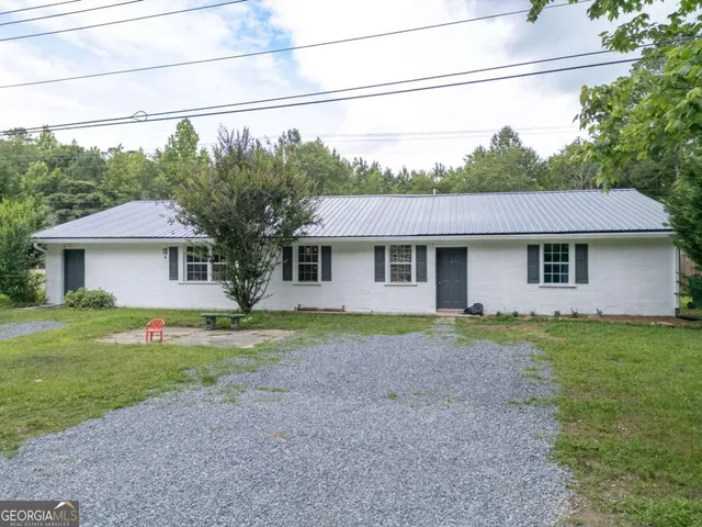 a front view of a house with a yard and trees