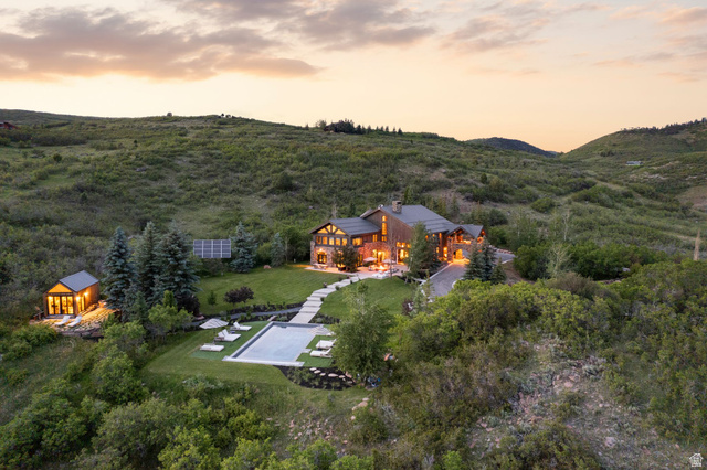 5971 Maple Ridge Trail Oakley, UT 84055 - Photo 2 of 43 Crafted stone and timber residence with a large outdoor pool, accompanying pool house, and a manicured lawn