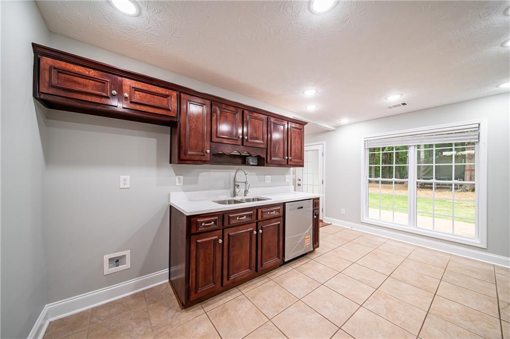 1927 Lee Road Salem, AL 36874 - Photo 24 of 45 Kitchen featuring recessed lighting, light tile patterned floors, stainless steel dishwasher, a textured ceiling, and dark brown cabinetry