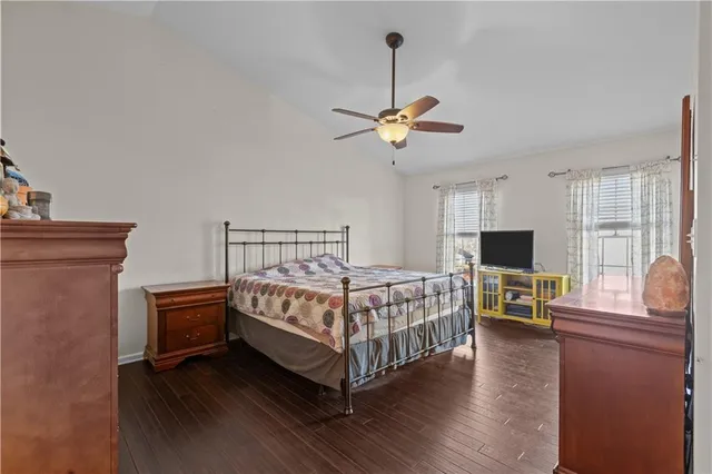 a bedroom with a bed a dresser and wooden floor
