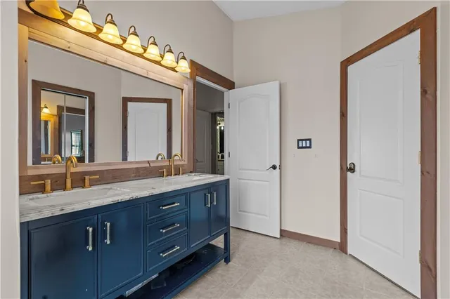 a bathroom with a granite countertop double vanity sink and a mirror