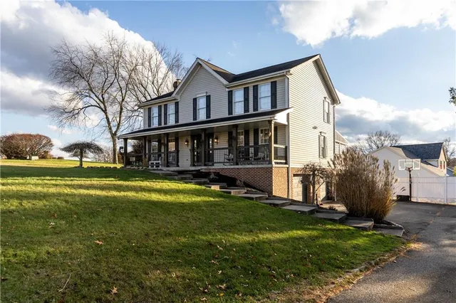 a view of a house with a yard and sitting area
