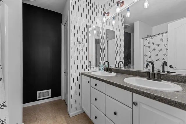 a bathroom with double sink and a mirror