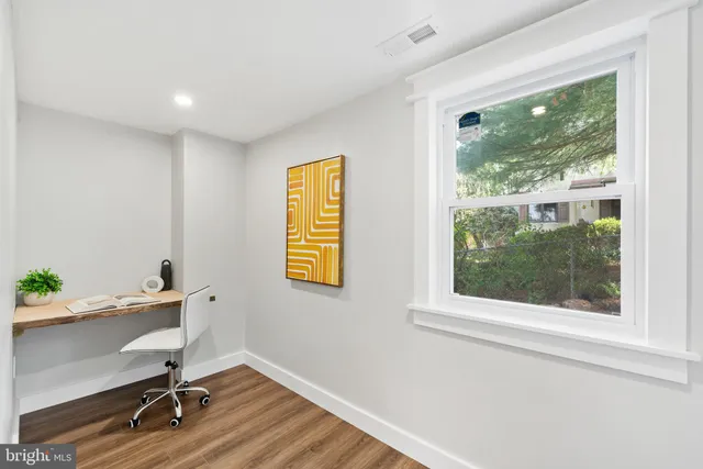 a workspace with wooden floor and a window