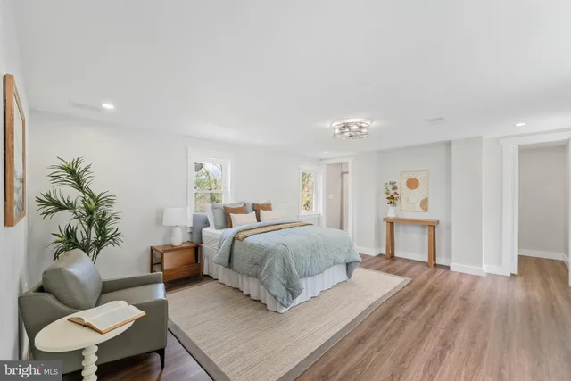 a spacious bedroom with a bed a couch and a potted plant