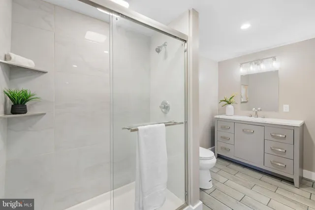 a spacious bathroom with a double vanity sink a large mirror a shower and