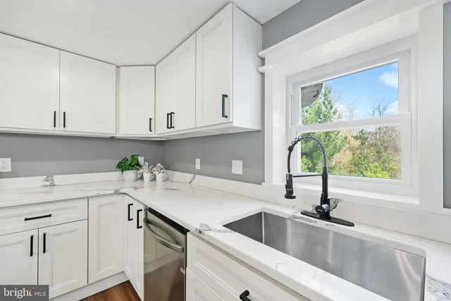 a kitchen with stainless steel appliances granite countertop a sink a stove and cabinets