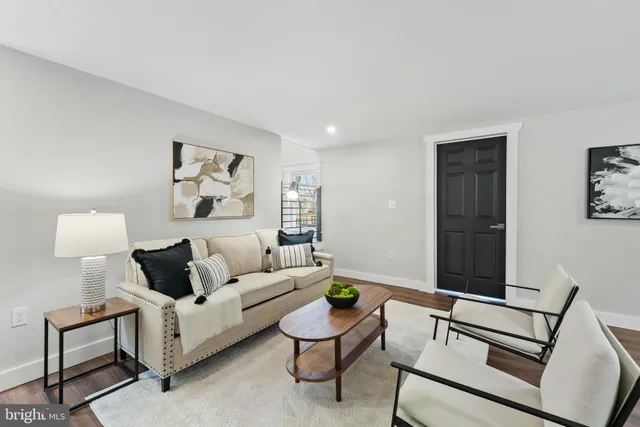 a living room with furniture and a painting on the wall