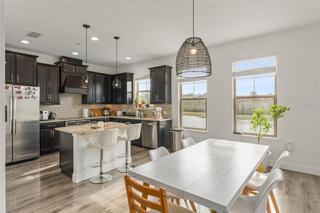 10814 Sunset Ridge Lane Orlando, FL 32832 - Photo 12 of 42 a kitchen with stainless steel appliances granite countertop a stove refrigerator a oven a sink dishwasher and white cabinets with wooden floor