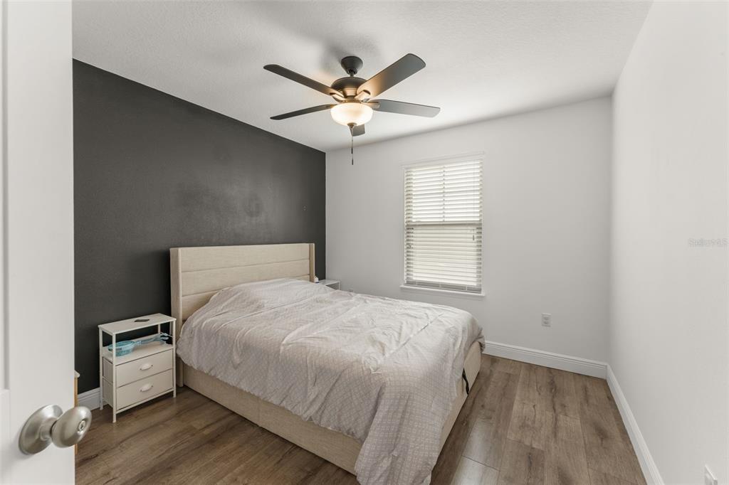 10814 Sunset Ridge Lane Orlando, FL 32832 - Photo 26 of 42 a bedroom with a large bed and a ceiling fan