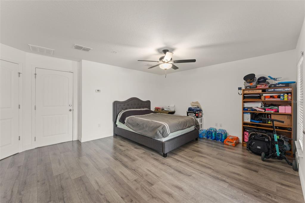 10814 Sunset Ridge Lane Orlando, FL 32832 - Photo 3 of 42 a spacious bedroom with a bed and a book shelf