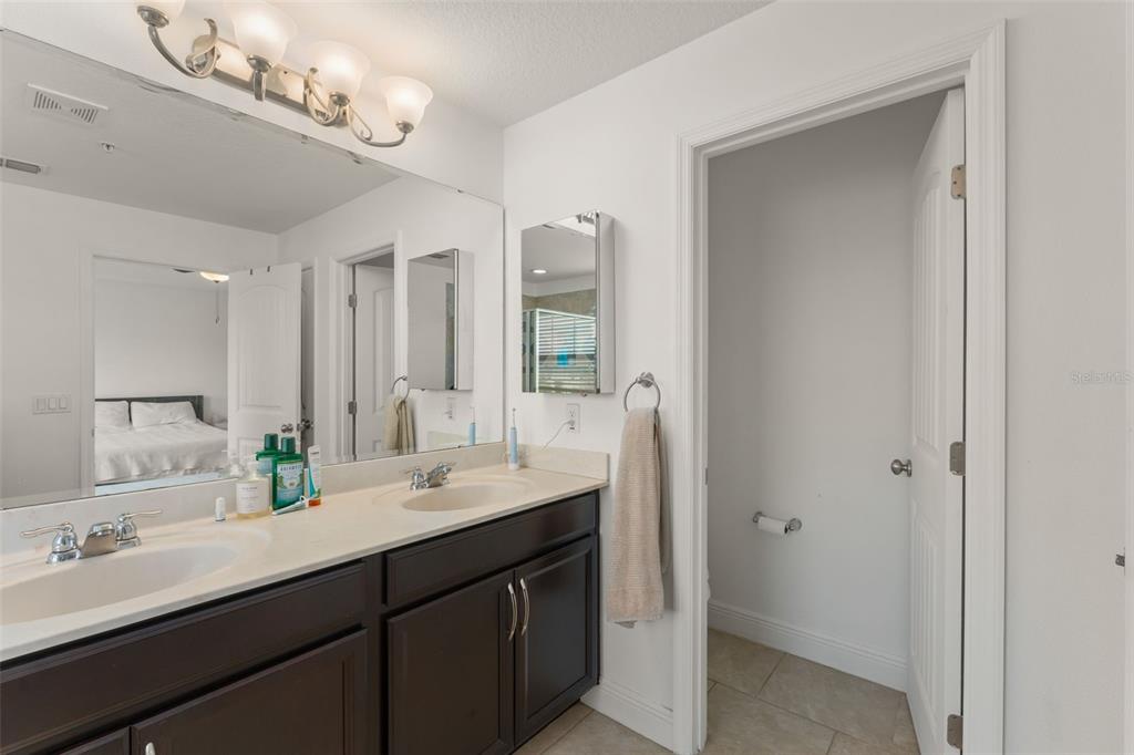 10814 Sunset Ridge Lane Orlando, FL 32832 - Photo 35 of 42 a bathroom with a double vanity sink a large mirror and a shower