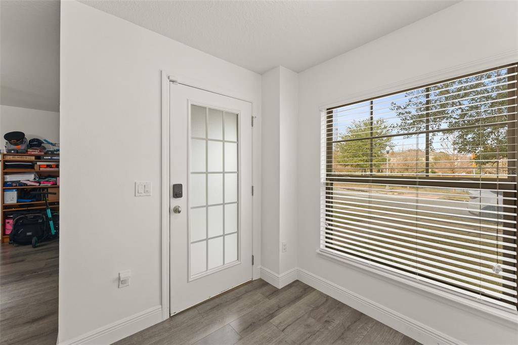 10814 Sunset Ridge Lane Orlando, FL 32832 - Photo 5 of 42 an empty room with wooden floor and windows