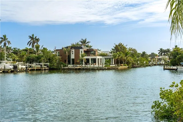 a view of a ocean with boats and trees in the background
