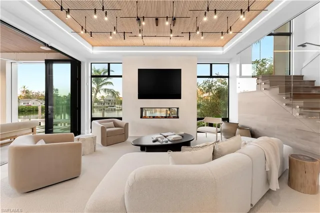 a living room with furniture a flat screen tv and a chandelier