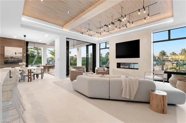 a living room with furniture a flat screen tv and a large window