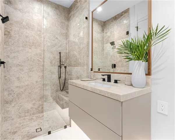 a bathroom with a granite countertop sink a mirror and a shower
