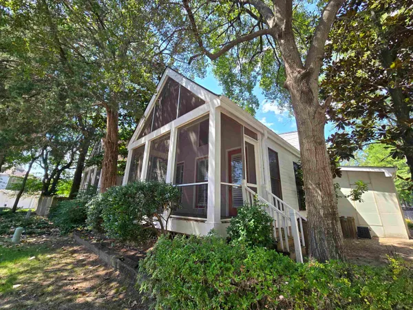 a kitchen with stainless steel appliances granite countertop a refrigerator a sink dishwasher a oven and a dining table with wooden floor