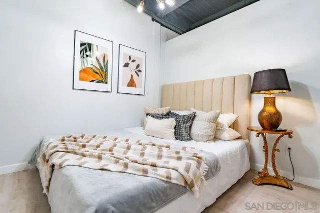 a bedroom with a bed and wooden floor