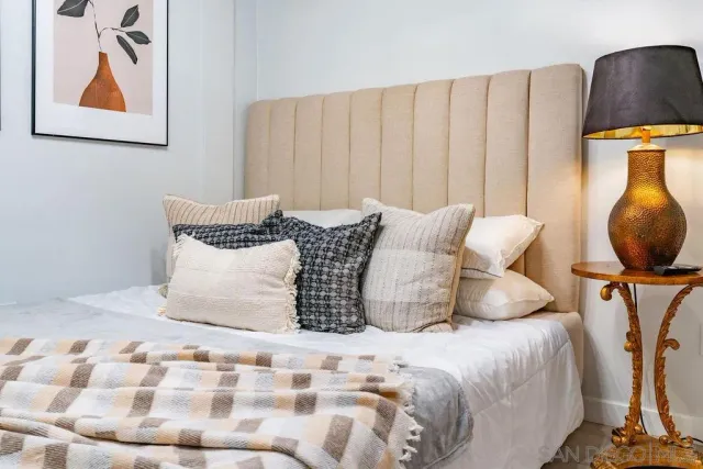 a bedroom with a bed and a painting on the wall