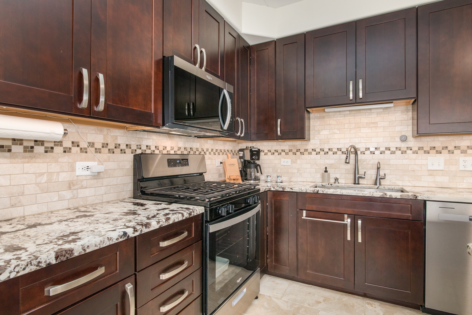 1705 Pavilion Way, Unit 401 Park Ridge, IL 60068 - Photo 11 of 25 a kitchen with stainless steel appliances granite countertop a sink stove and microwave