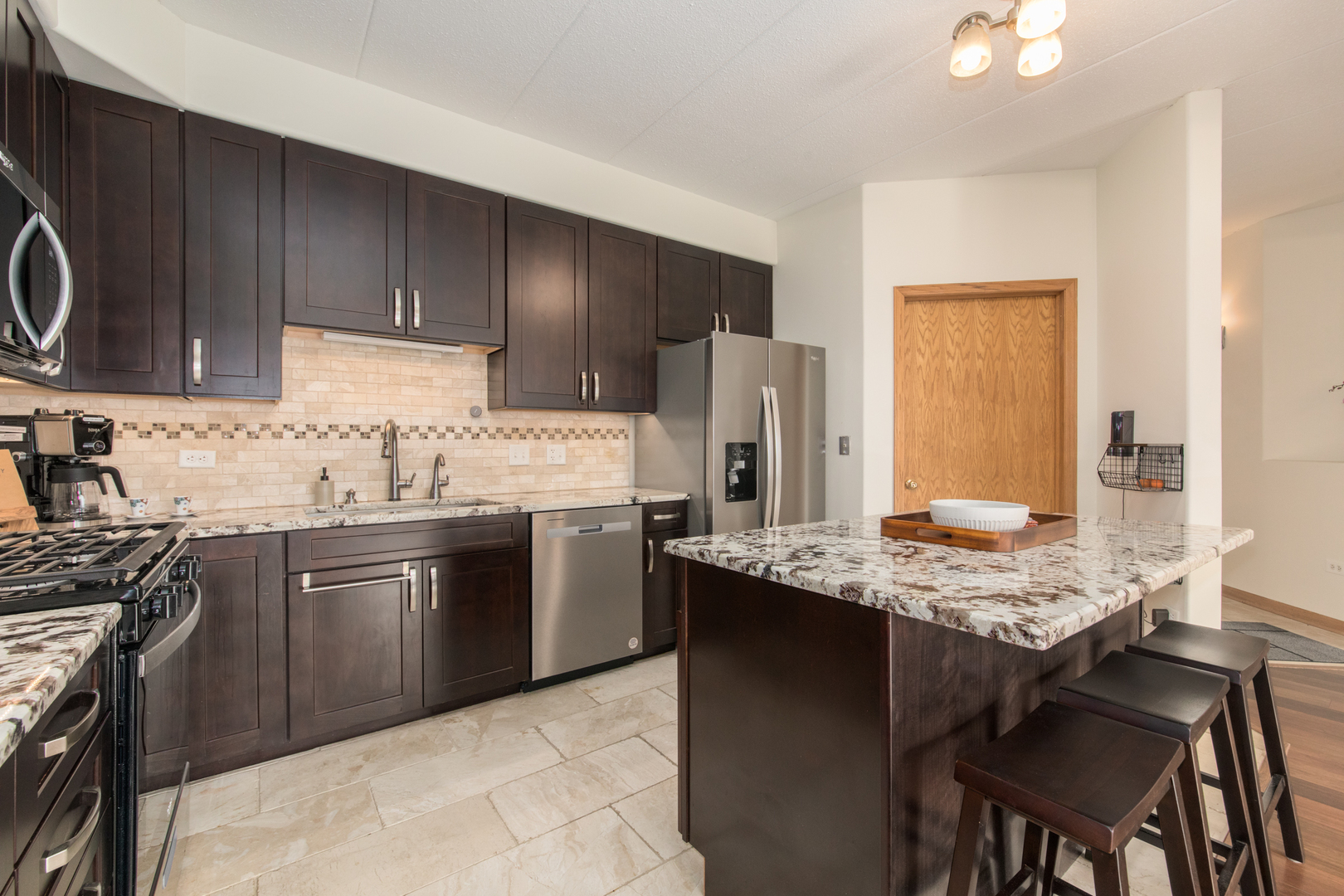 1705 Pavilion Way, Unit 401 Park Ridge, IL 60068 - Photo 8 of 25 a kitchen with stainless steel appliances granite countertop a sink stove refrigerator and cabinets