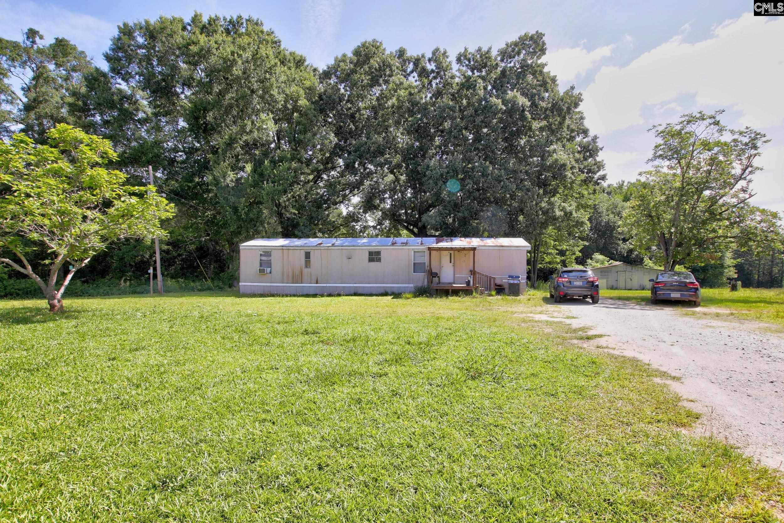 3140 Highway 702 Chappells, SC 29037 - Photo 35 of 39 a front view of a house with a garden and sitting area