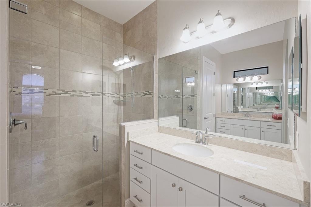 1316 Kendari Terrace Naples, FL 34113 - Photo 11 of 31 a bathroom with a shower sink vanity granite and mirror