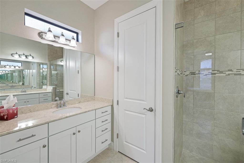 1316 Kendari Terrace Naples, FL 34113 - Photo 12 of 31 a bathroom with a double vanity sink and a mirror