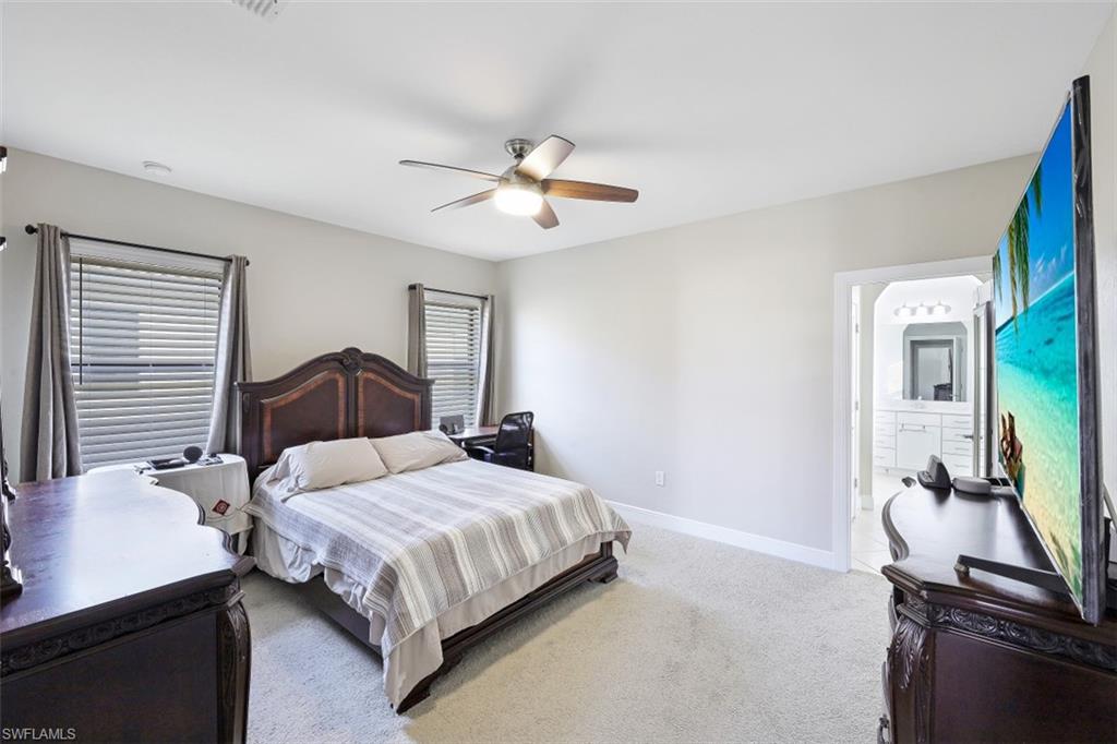 1316 Kendari Terrace Naples, FL 34113 - Photo 13 of 31 a bedroom with a bed and a chandelier
