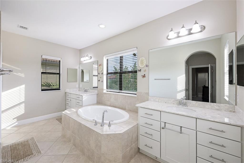 1316 Kendari Terrace Naples, FL 34113 - Photo 14 of 31 a spacious bathroom with a granite countertop sink a toilet a mirror and window