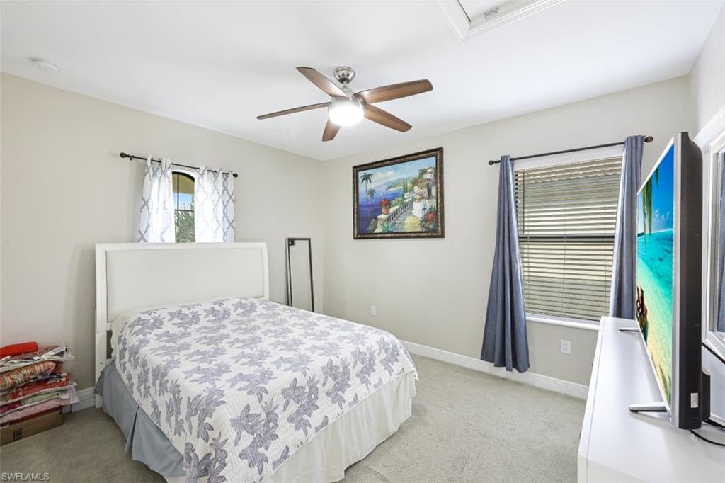 1316 Kendari Terrace Naples, FL 34113 - Photo 15 of 31 a bedroom with a large bed and a chandelier