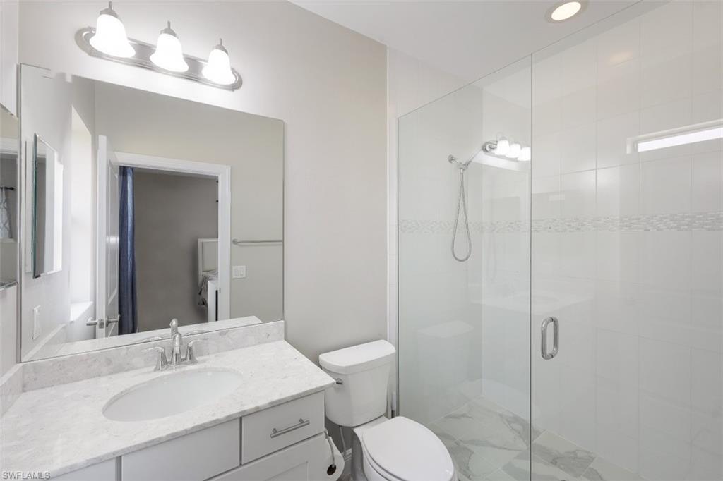 1316 Kendari Terrace Naples, FL 34113 - Photo 16 of 31 a bathroom with a sink vanity granite toilet and shower