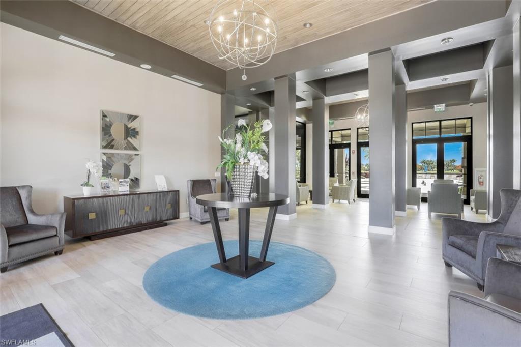 1316 Kendari Terrace Naples, FL 34113 - Photo 24 of 31 a living room with furniture a chandelier and a dining room
