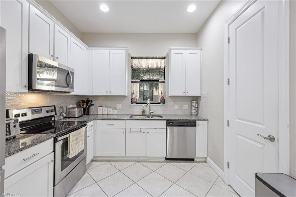 1316 Kendari Terrace Naples, FL 34113 - Photo 7 of 31 a kitchen with white cabinets appliances and a sink