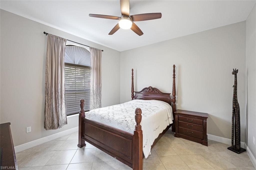 1316 Kendari Terrace Naples, FL 34113 - Photo 10 of 31 a bedroom with a bed and a chandelier