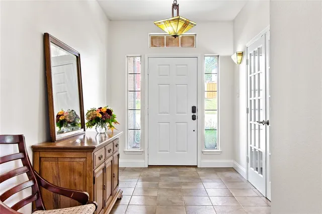 an entryway with a dining room and chandelier fan