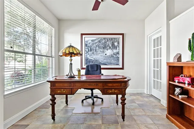 a view of a workspace with furniture and a window