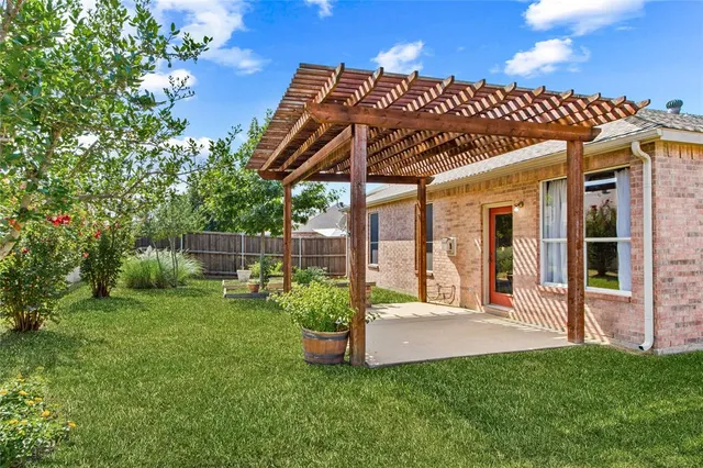 a view of a chair and table in backyard of the house