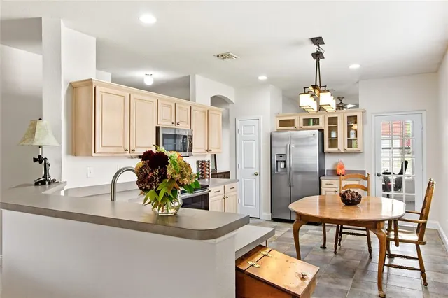 a kitchen with sink refrigerator dining table and chairs