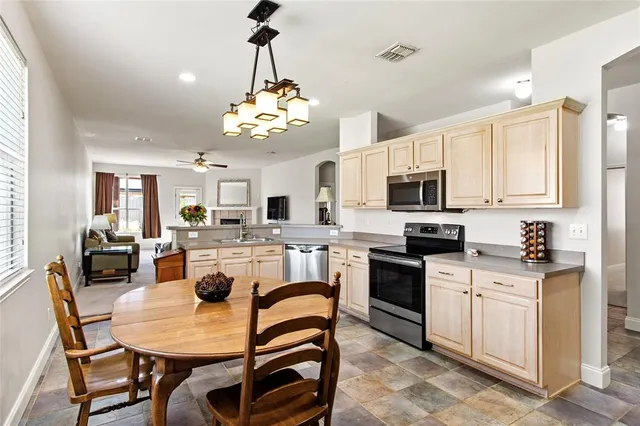 a view of dining table chairs and kitchen