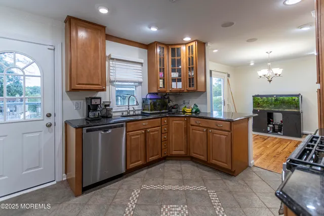 a kitchen with granite countertop a stove a sink and a refrigerator