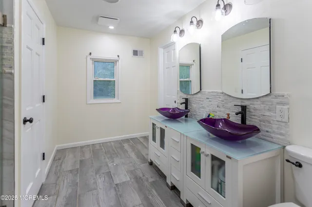 a kitchen with sink a stove and wooden floor