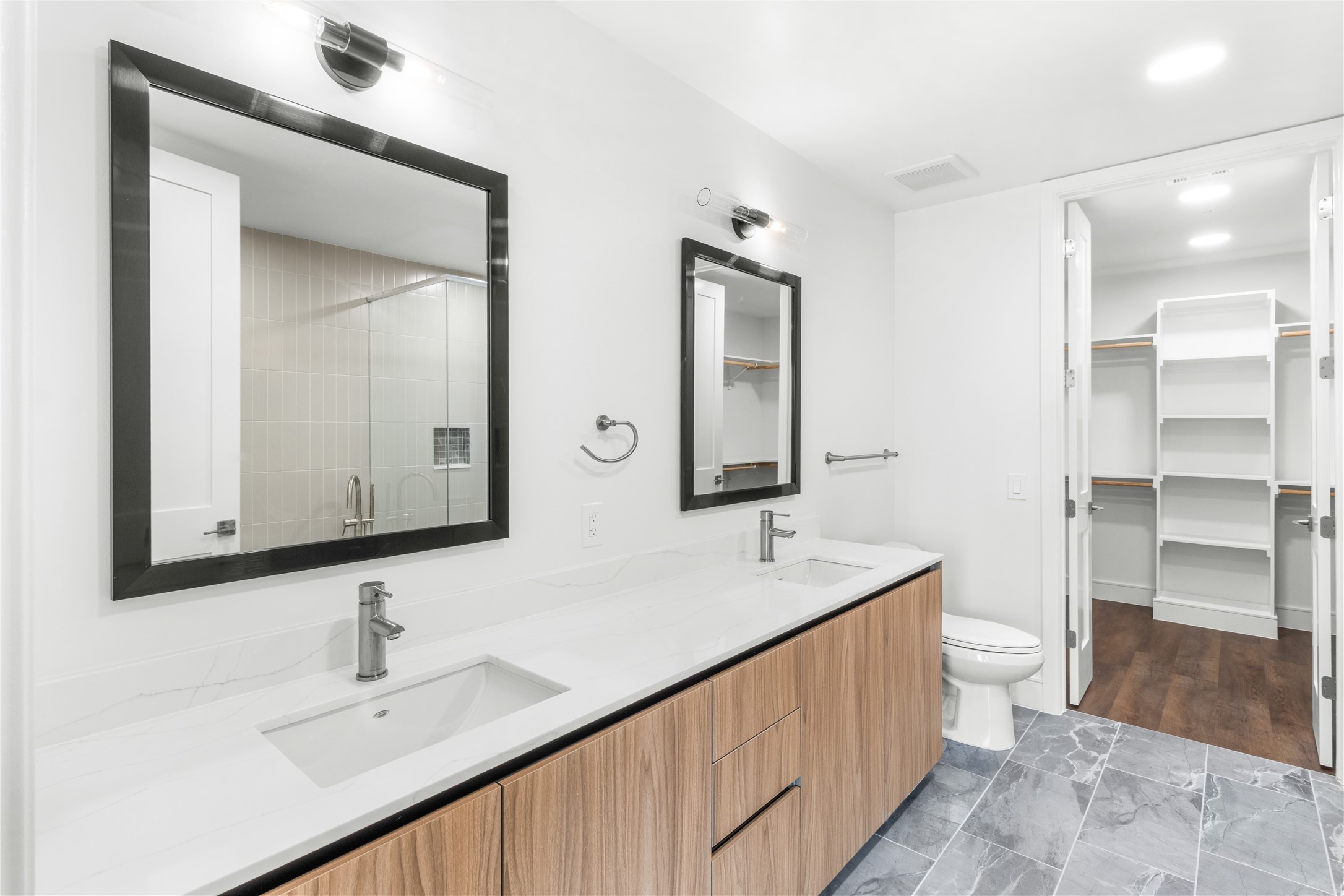 2311 Westheimer Road, Unit 529 Houston, TX 77098 - Photo 19 of 33 a bathroom with a double vanity sink and mirror with toilet