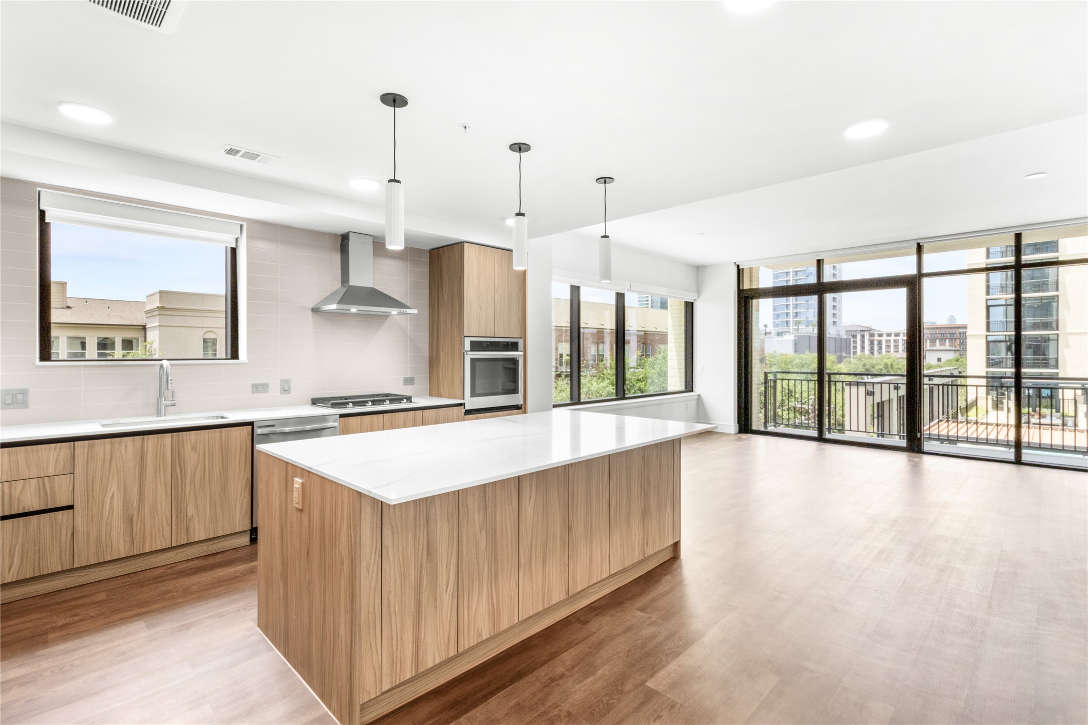 2311 Westheimer Road, Unit 529 Houston, TX 77098 - Photo 2 of 33 a large kitchen with kitchen island a large counter space a sink appliances and a large window