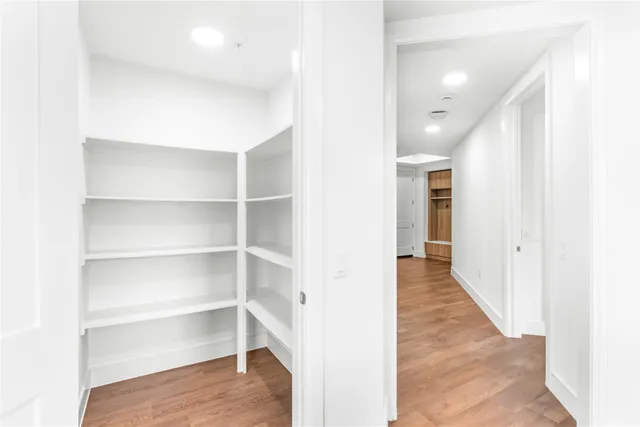 a view of a hallway with wooden floor and staircase